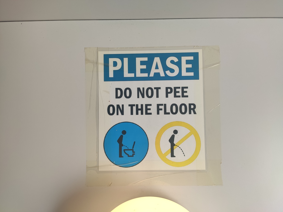 Schild: “Please do not pee on the floor” in der öffentlichen Toilette des Jachthafens von Vittoriosa (Birgu)