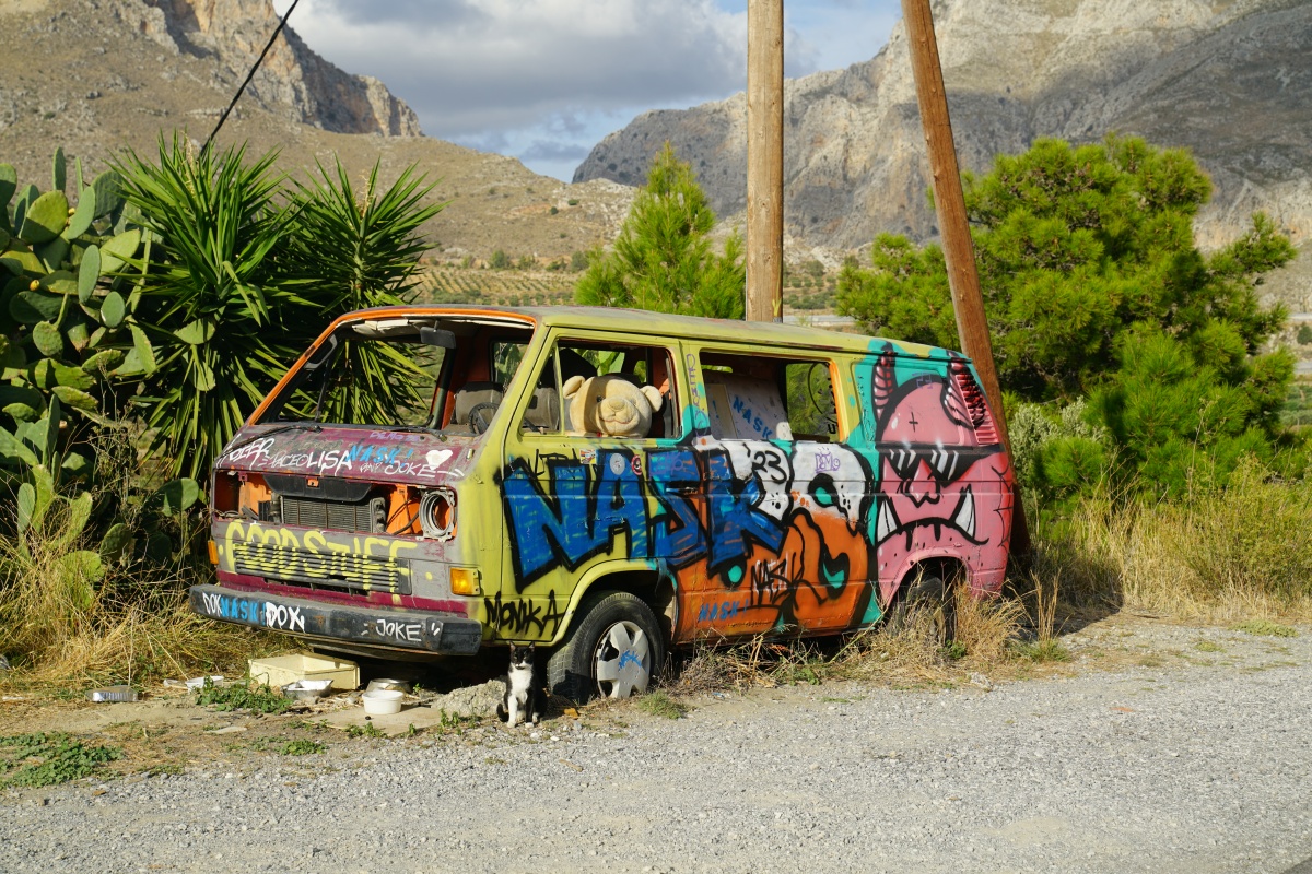 Alter VW-Bus mit riesigem Plüschbär am Steuer und Katze davor an der Straße nach Préveli auf Kreta