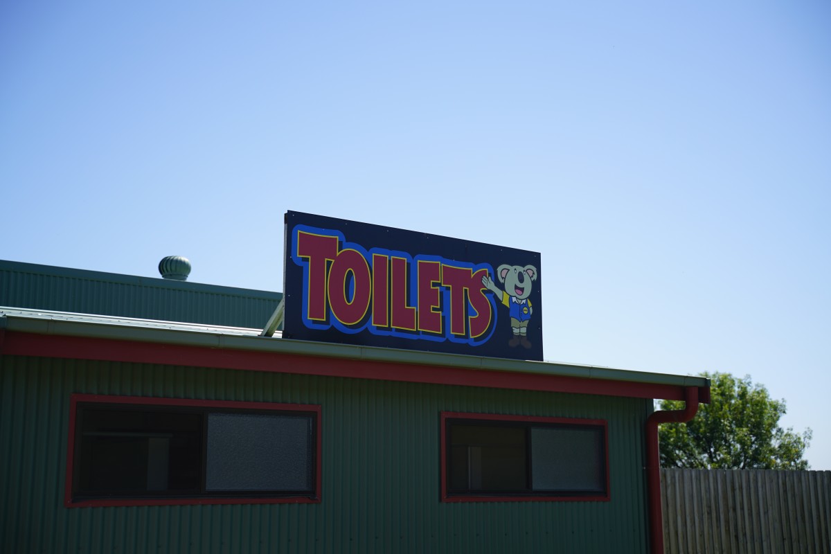 Schild mit Koala über einem Toilettenhäuschen