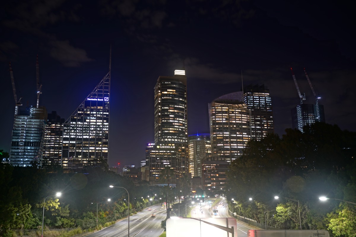 Die Straße M1, die durch Sydney führt, bei Nacht, mit Skyline dahinter