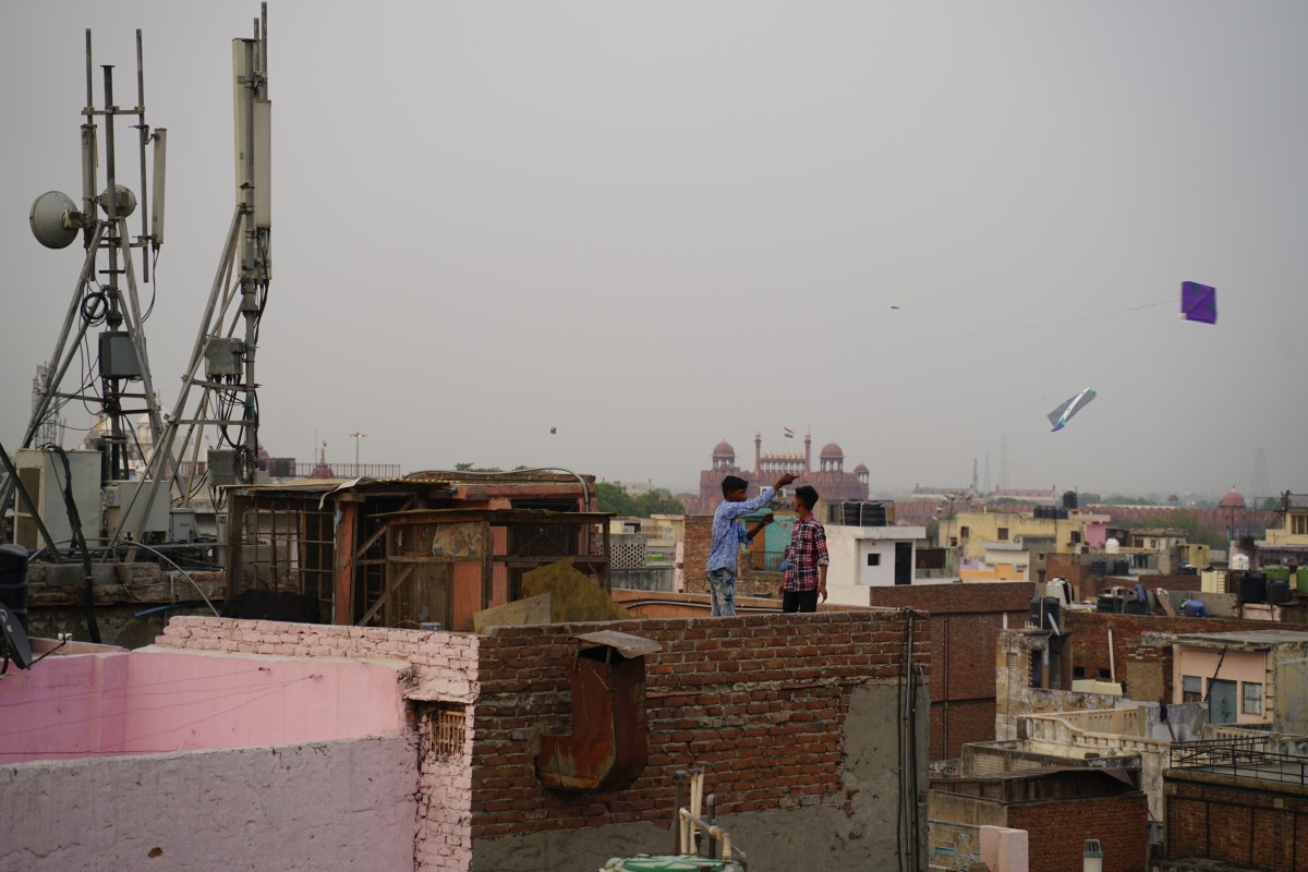 Zwei Jungen lassen auf einem Dach Drachen steigen