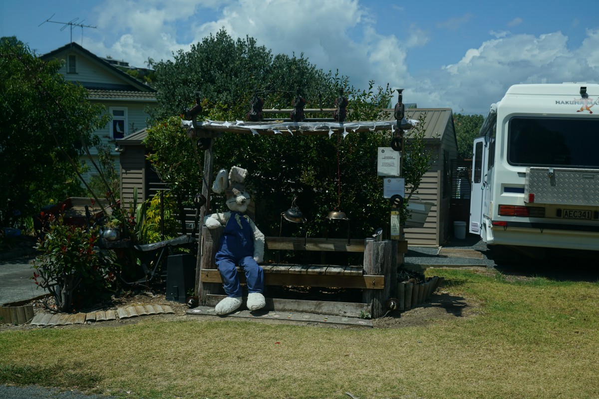 Menschengroße Hasenfigur sitzt auf einer mit elektrischen Bauteilen versehenen Bank