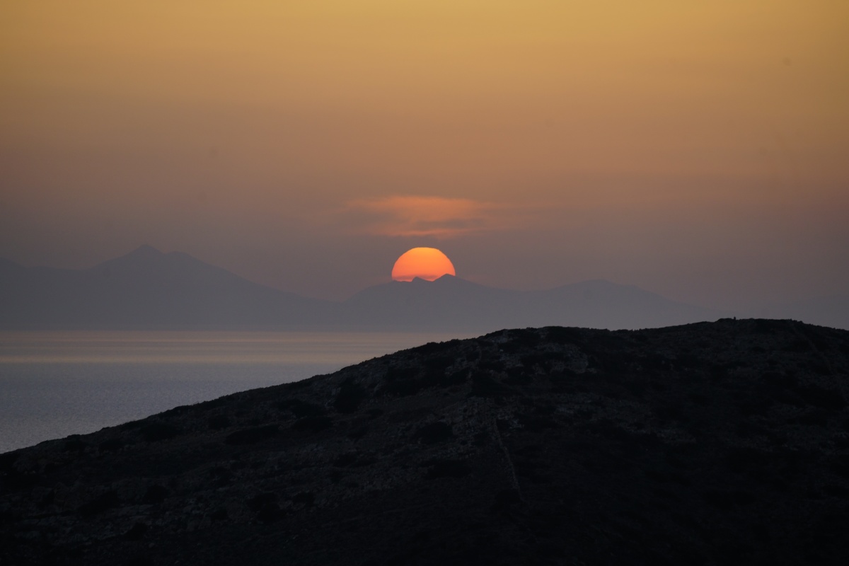 Die Sonne versinkt in den Bergen von Sikinos