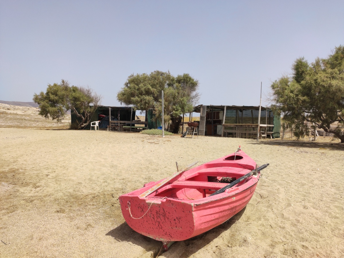 Am Strand von Didymi liegt ein rosa Holz-Ruderboot