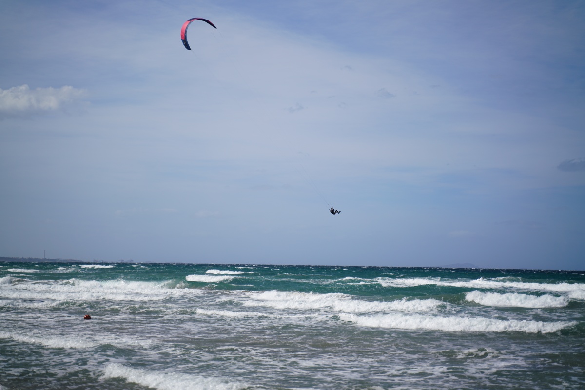 Ein Kitesurfer am Strand von Marina di Sorso hebt ab