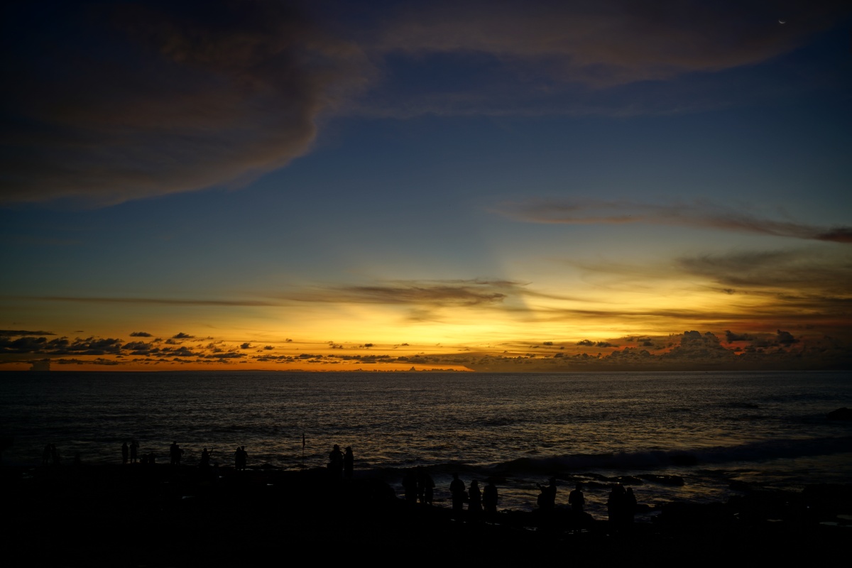 Menschen betrachten in Pura Tanah Lot auf Bali den Sonnenuntergang