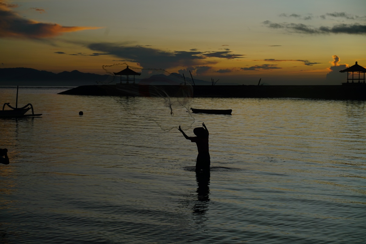 Fischer bei Pantai Karang in Sanur auf Bali beim Fischen mit dem Wurfnetz
