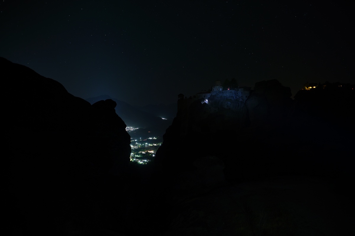 Varlaám (etwas rechts der Mitte) und Megálo Metéoro (Metamórphosis, ganz rechts), Kastráki (etwa links der Mitte in der Felsspalte) vom Varlaám-Aussichtsfelsen aus gesehen bei Nacht