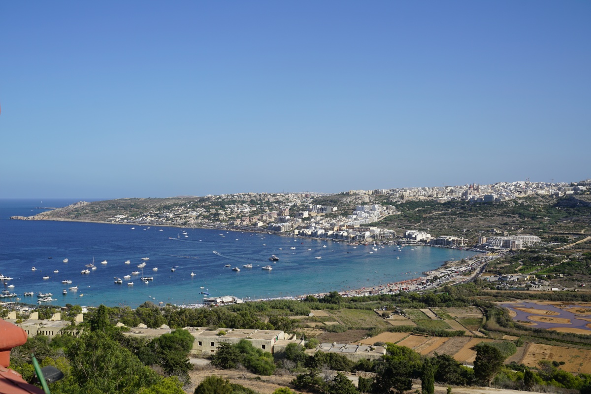 Mellieħa-Bucht auf Malta, gesehen vom Roten Turm aus; rechts am Rand mit den roten Inseln im Wasser das Għadira Nature Reserve