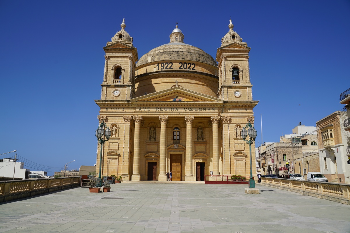 Kollegiatkirche der Aufnahme der Gesegneten Jungfrau Maria in den Himmel in Mġarr auf Malta, davor die Markierungen, wie man Corona-konform zu stehen hat(te)
