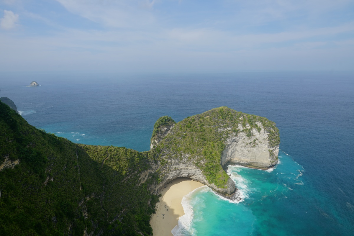 Kelingking Beach (Kap T-Rex), links die Felsentor-Insel Nusa Batumelawang