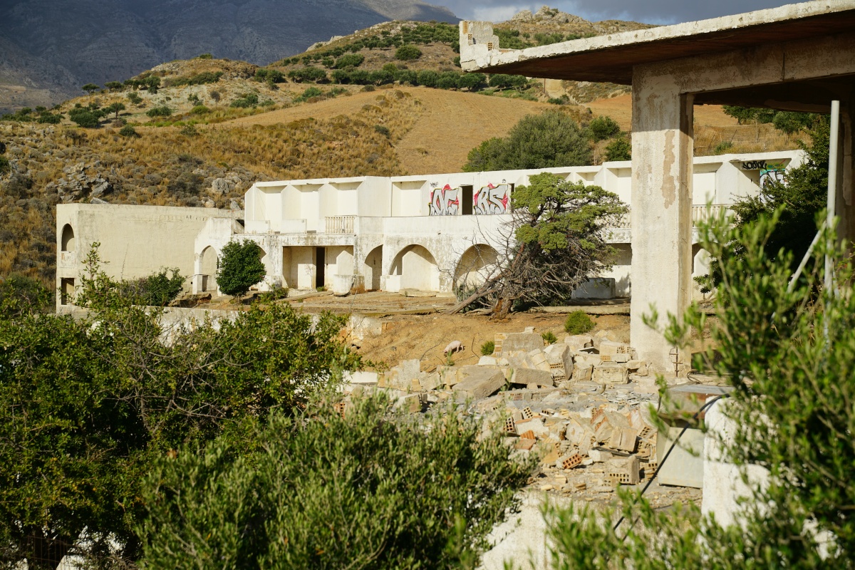 Hotelrohbau-Ruine, die jetzt als Schweinestall dient, in Schinária auf Kreta, Schwein in der Mitte des Bildes