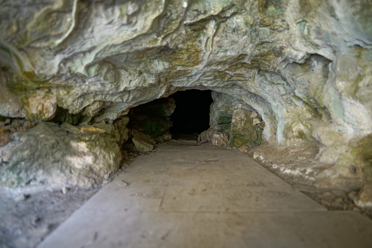 Spanholzplatten führen in die Finsternis der Höhle des Heiligen Johannes auf Irakliá