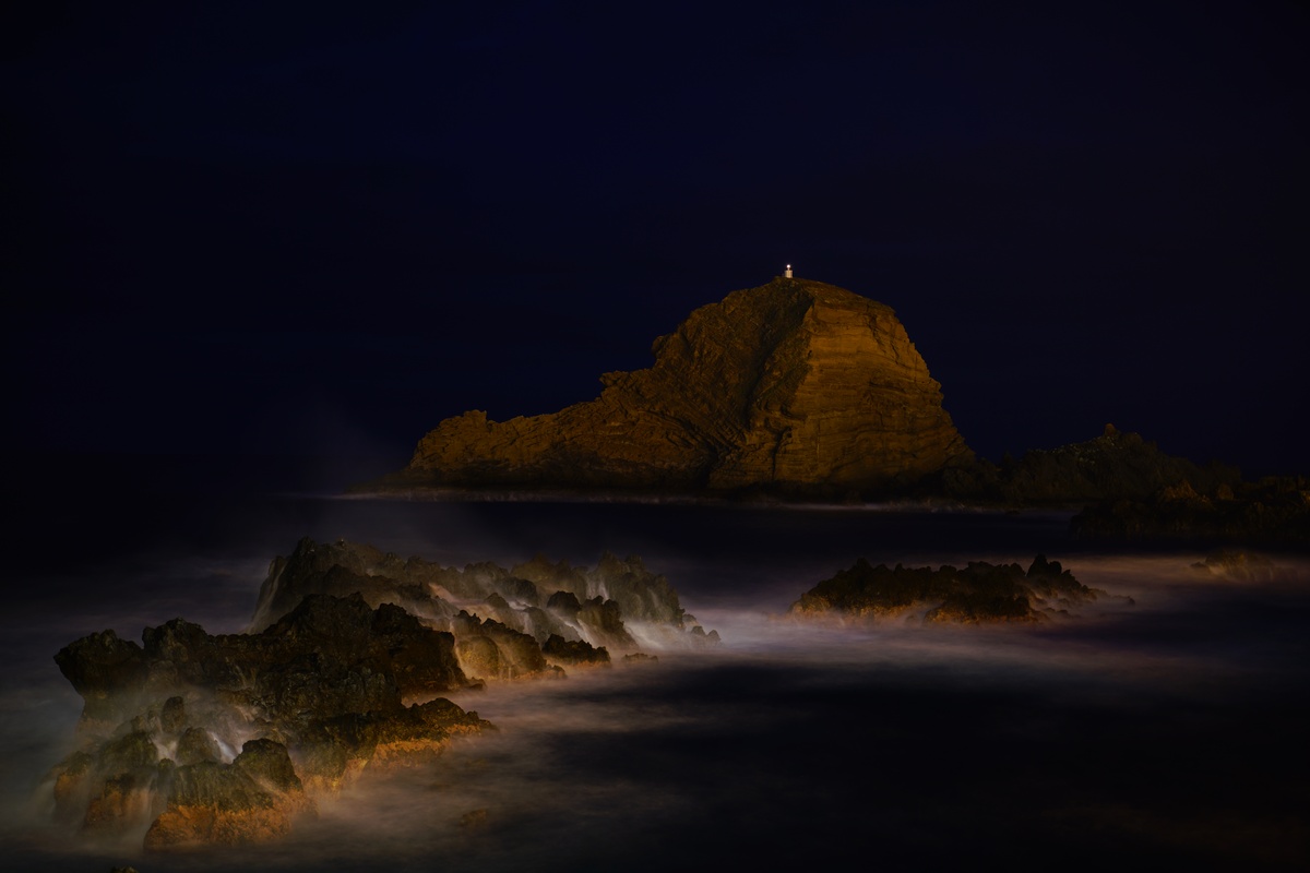 Felsen bei den Naturschwimmbädern von Porto Moniz auf Madeira bei Nacht, in der Mitte die Ilhéu Mole