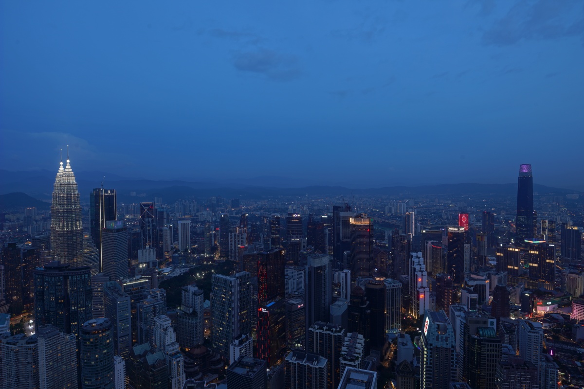 Petronas Towers (links) in Kuala Lumpur in der Blauen Stunde, gesehen vom KL Tower