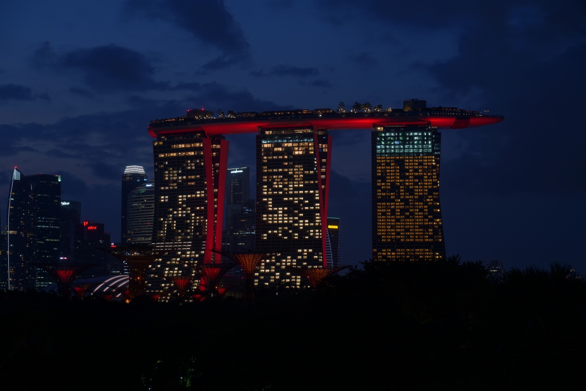 Blick auf das Marina Bay Sands und die Supertrees (unten links in rot) während der Blauen Stunde in Singapur