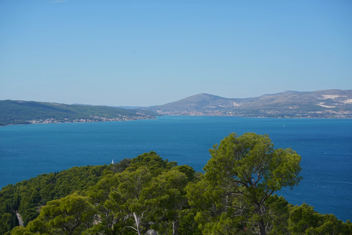 Blick von unterhalb des Vidikovac-Aussichtsturms in Richtung Trogir (die Insel Trogir ist durch einen Hügel verdeckt), ganz rechts der Flughafen