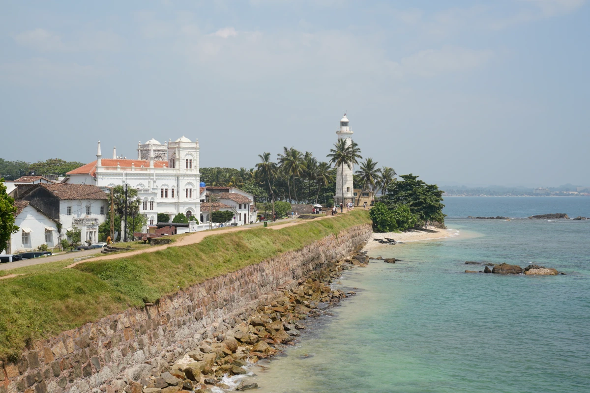 Leuchtturm von Galle an der Südostspitze von Galle Fort, mit Strand und links daneben die Meeran-Moschee