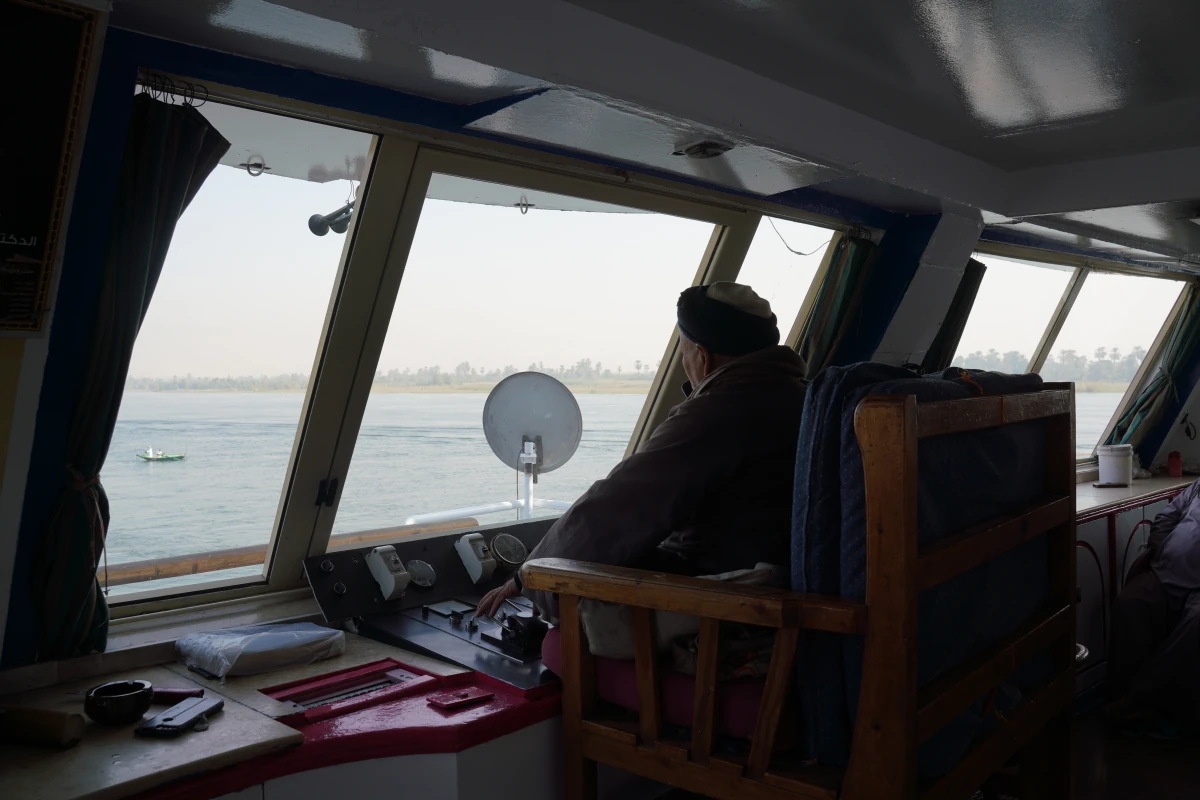 Der Kapitän der H/S Nile Vision sitzt im Schneidersitz auf der Brücke