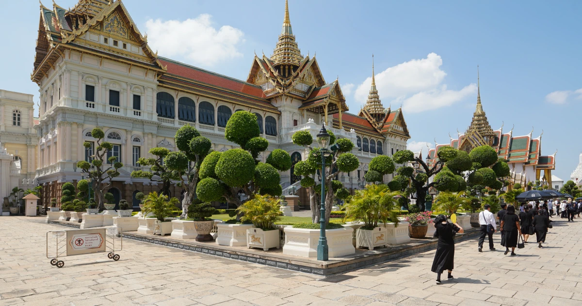 Chakri Maha Prasat (links) mit Trauernden, die zum Phra Thinang Dusit Maha Prasat gehen (rechts), im Großen Palast von Bangkok